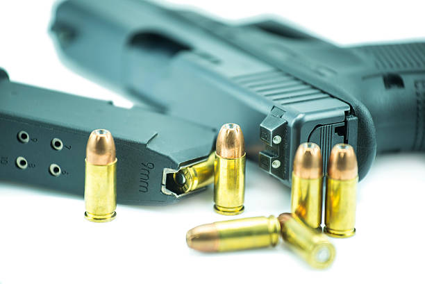 istock 9mm bullets and black gun pistol isolated on white background. 477097522