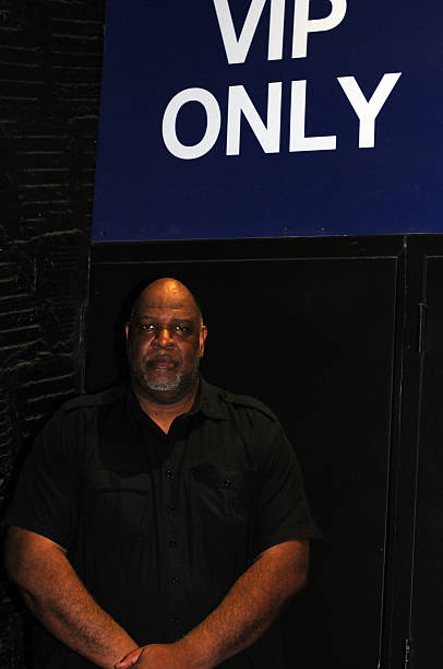 NYC bouncer VIP only Portrait of a New York City bouncer at night with a VIP only sign outside of a nightclub . Shot with a Nikon 300 with a Nikkor 50mm lens and Bolt flash.  bouncer security staff stock pictures, royalty-free photos & images