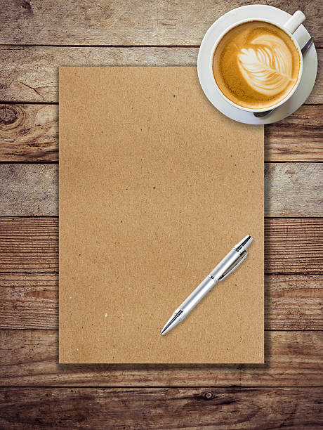 istock brown paper and coffee on wood background with pen 477100358
