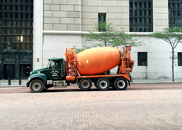 A concrete mixer (also commonly called a cement mixer) is a device that homogeneously combines cement, aggregate such as sand or gravel, and water to form concrete. A typical concrete mixer uses a revolving drum to mix the components. For smaller volume works portable concrete mixers are often used so that the concrete can be made at the construction site, giving the workers ample time to use the concrete before it hardens. An alternative to a machine is mixing concrete by hand. This is usually done in a wheelbarrow; however, several companies have recently begun to sell modified tarps for this purpose.