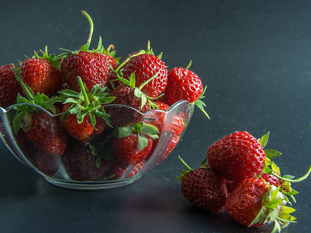 istock fresh red strawberries in a bowl on black 477105564