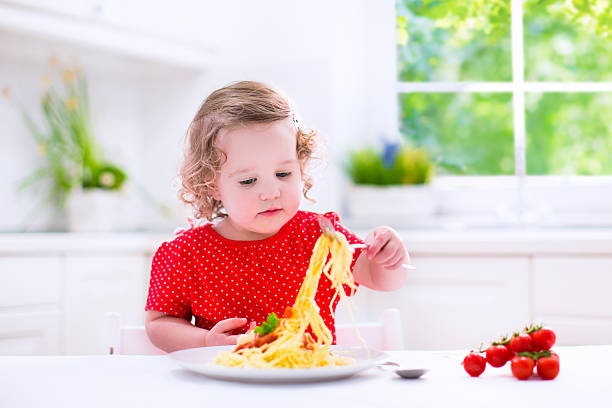 istock Little child eating pasta 477106372