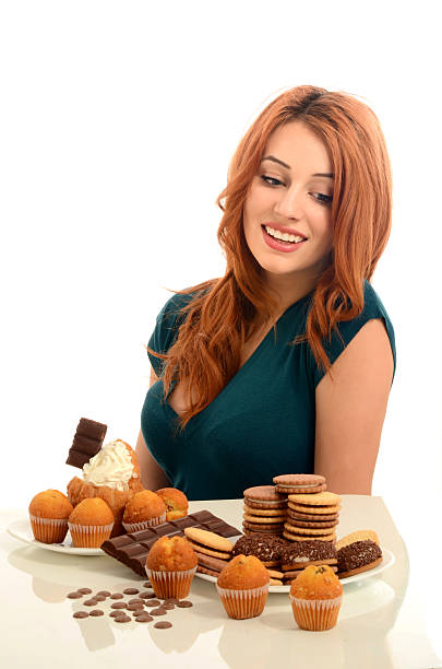 istock Girl craving lots of biscuits, muffins, cake. 477106918