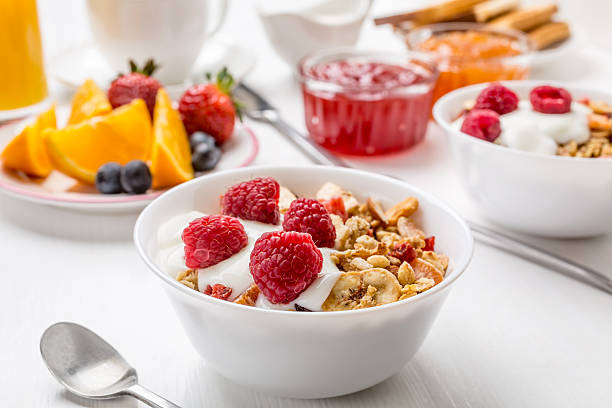 Healthy Breakfast Meal Healthy Breakfast Meal - Bowl of Baked Fruit, Oat and Nut Granola with Yogurt and Raspberries raspberry jam stock pictures, royalty-free photos & images