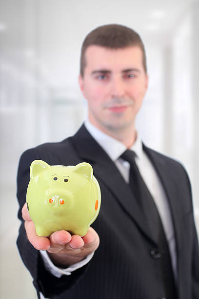istock Businessman with a piggy bank 477109268