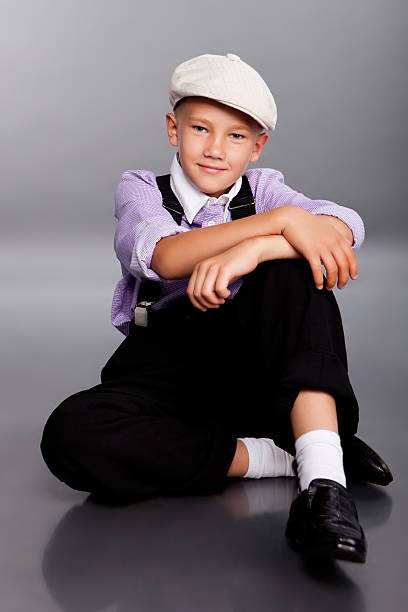 istock Old fashioned boy sitting on gray background 477110814