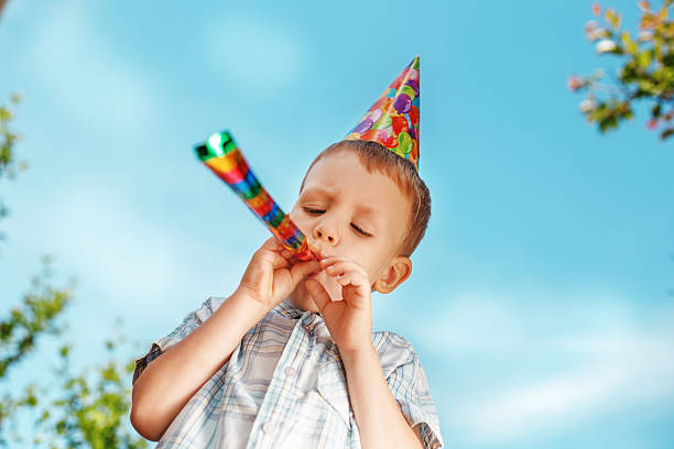 istock Little boy having fun and blows a whistle 477111266