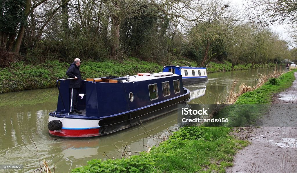 man driving narrow boat on canal 2015 Stock Photo