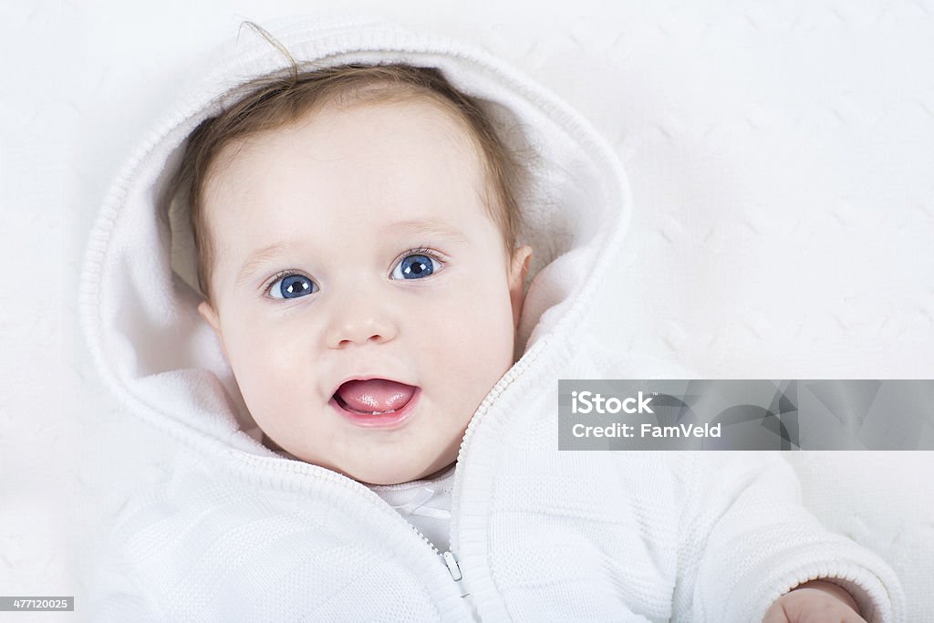 Adorável bebê com olhos azuis vestindo jaqueta jaqueta branca quente - Foto de stock de Alegria royalty-free