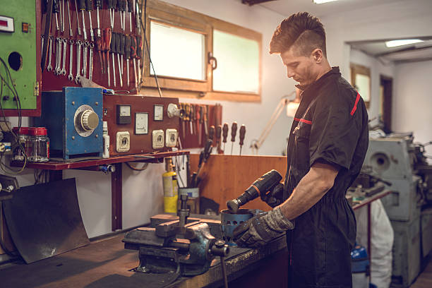 istock Young mechanic working with wire brush drill in a workshop. 477124352