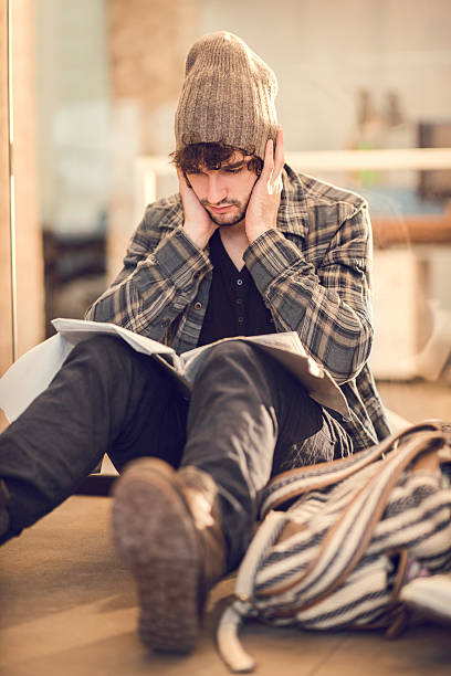 Serious male student sitting on the floor and learning for his exams.