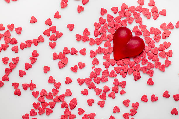 istock Red heart-shaped sprinkles on white 477125946