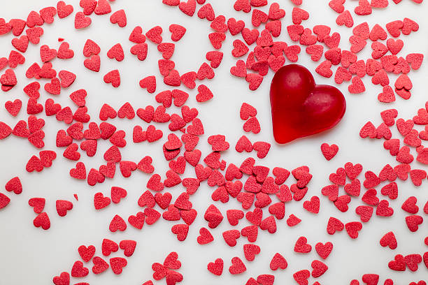 istock Red heart-shaped sprinkles on white 477125966