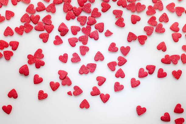 Red heart-shaped sprinkles on white