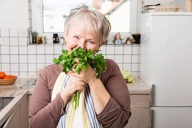 istock senior woman in kitchen with parsley herbs 477126651