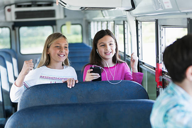 istock Girls riding school bus 477130357
