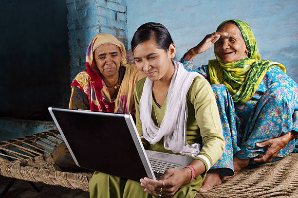 mãe e filha segurando o computador portátil em casa - indian subcontinent culture imagens e fotografias de stock