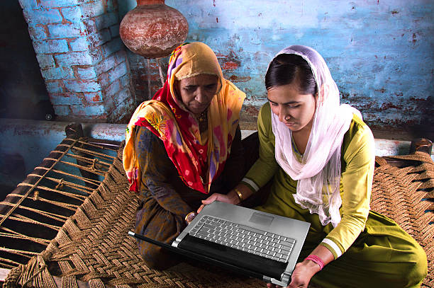 istock Mother and Daughter Holding Laptop at Home 477135588