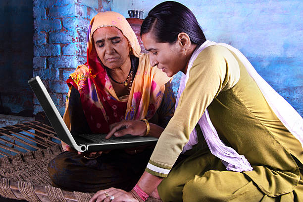istock Mother and Daughter Holding Laptop at Home 477135590