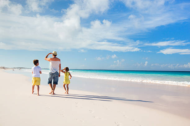 istock Father with kids at beach 477140159