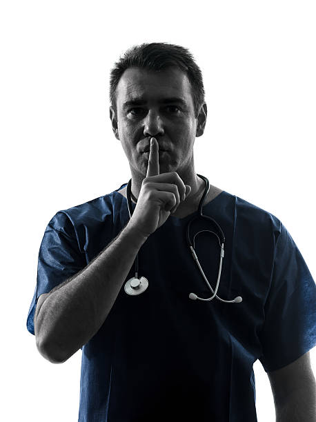 istock doctor man surgeon hushing portrait silhouette 477140437