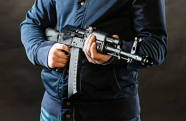 terrorist holding kalashnikov rifle isolated on a black background