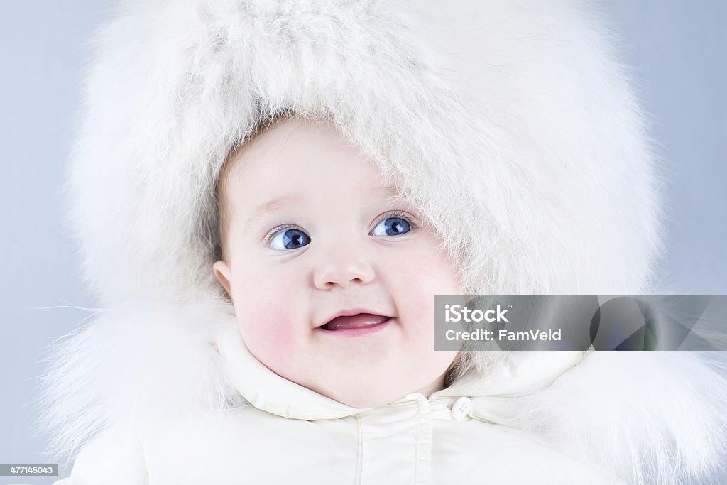 Lustiger laughing baby im big white Pelzmütze - Lizenzfrei Baby Stock-Foto