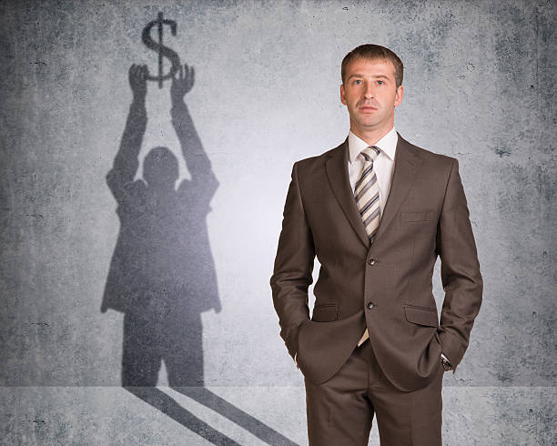 istock Businessman with shadow holding dollar sign 477145586