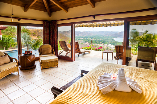 A stunning luxury villa bedroom with an amazing view overlooking a beach and Pacific Ocean in Guanacaste, Costa Rica. 