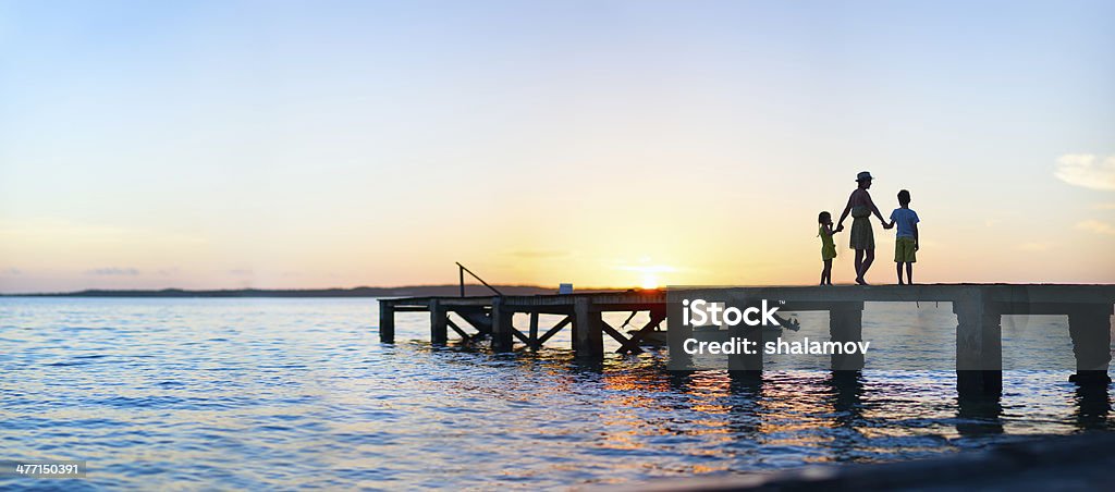 Family sunset silhouettes Family silhouettes on a bridge at sunset Family Stock Photo