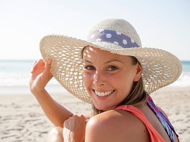 Smile girl at beach happy girl smiling portrait in the beach  wearing a  hat with the sea and horizon in the background 21st century photos stock pictures, royalty-free photos & images