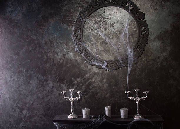 Decorative Round Frame Above Candles and Candelabras on Eerie Cobweb Covered Mantle in Haunted House Setting