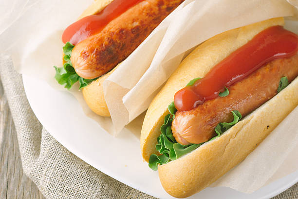istock Hotdogs on wooden table 477153880