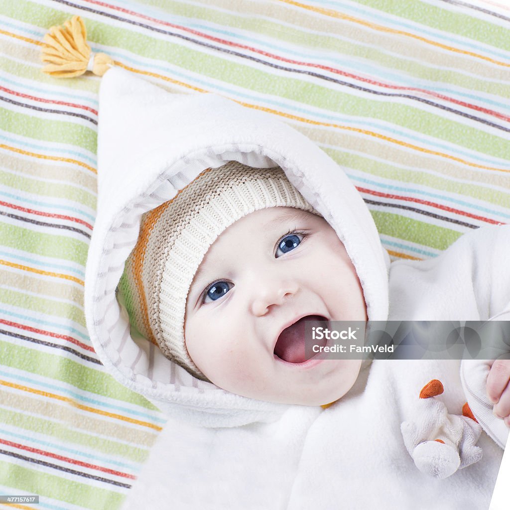 Милый laughing baby Девушка в теплую шапку и Белый жакет - Стоковые фото Веселье роялти-фри
