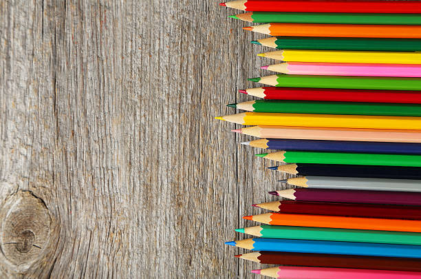 istock Colour pencils on grey wooden background 477157700