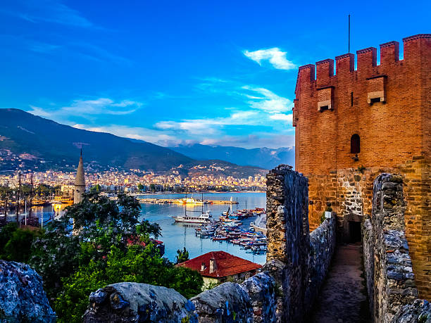 Red Tower (Kizil Kule)  Alanya Turkey Alanya, Turkey - May 02, 2015: Red Tower (Kizil Kule)   marina and the town of Alanya in sunset time. No people. alanya stock pictures, royalty-free photos & images