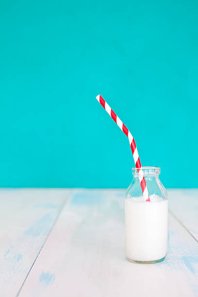 istock Milk bottle with straw and blue background 477159156