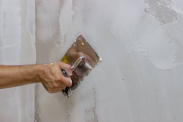 istock man hand with trowel plastering a wall 3 477165218