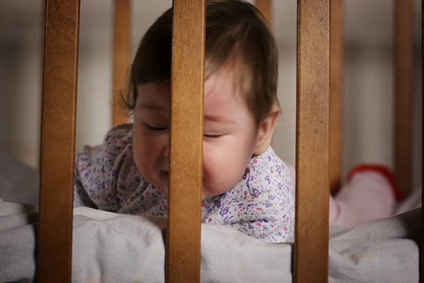 istock child playing in the bed behind bars 477169184