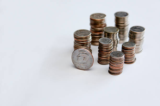 Stacks of Silver Coins Quarters, nickels, dimes all stacked up with a Kennedy Half dollar sitting up on its edge in the front of the stacks, all on a white background ten cents stock pictures, royalty-free photos & images