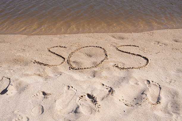 istock Word sos written in beach sand 477176790