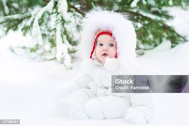 Foto de Bebê Bonito Vestindo Jaqueta De Inverno Quente E Chapéu Vermelho e mais fotos de stock de Bebê