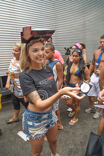 Street Carnival in Rio Rio de Janeiro, Brazil - March 2, 2014: Beautiful model that represents a cable TV program distributes condoms before Simpatia e Quase Amor group parades in Ipanema streets nudie suit stock pictures, royalty-free photos & images