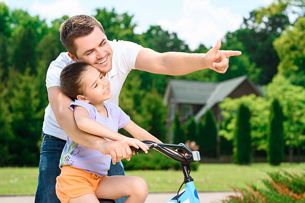 istock Father teaching daughter to ride a bike 477191070