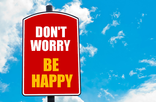 Don't Worry Be Happy motivational quote written on red road sign isolated over clear blue sky background. Concept  image with available copy space