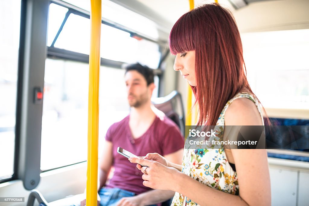 Friends talking and using the smartphone inside a bus Friends talking and using the smartphone 20-24 Years Stock Photo