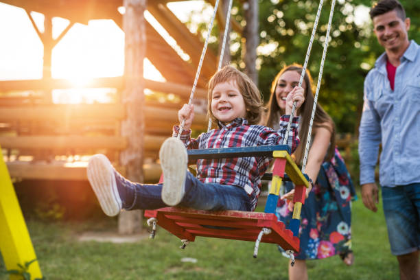 istock Young smiling parents swinging their son at sunset. 477195164