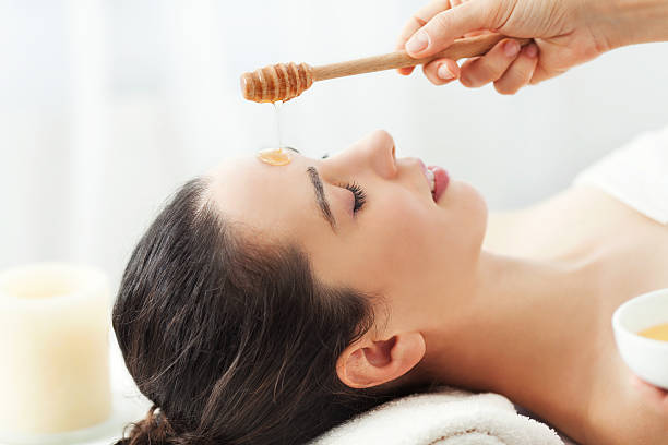 massaggio viso al miele - pampering massaging indoors adult foto e immagini stock