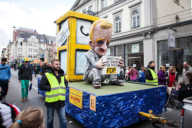 Street carnival in Wiesbaden 2014 Wiesbaden, Germany - March 2, 2014: Street carnival in Wiesbaden 2014. In the foreground a so called Motivwagen with huge caricatural figures dealing with german social or political issues - in this particular case with the downfall of German political party FDP. In the background some spectators, german free democratic party photos stock pictures, royalty-free photos & images