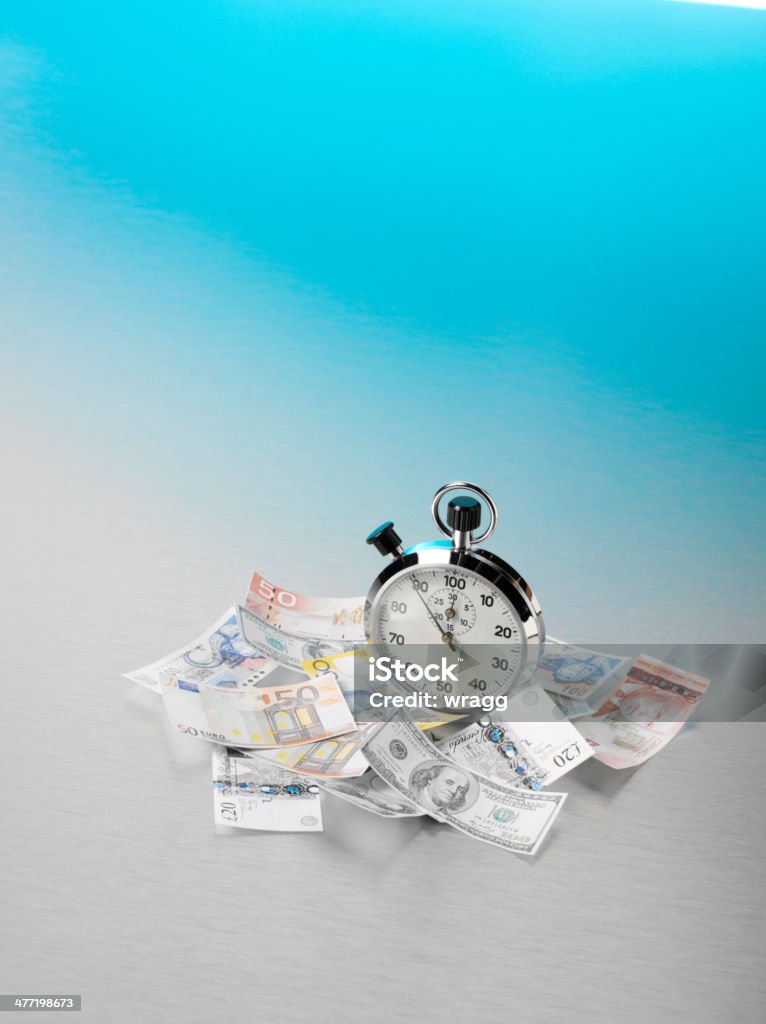 American, European and British Currency Scattered Around a Stopwatch American, European and British currency scattered around a stopwatch, with copy space on a stainless steel background with blue lighting. Time is money concept. American One Hundred Dollar Bill Stock Photo